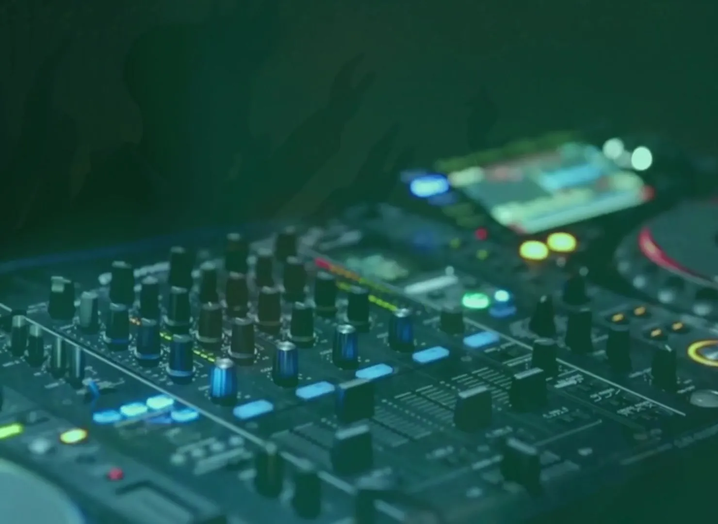 DJ-pult med mixer og afspillere i grønt lys